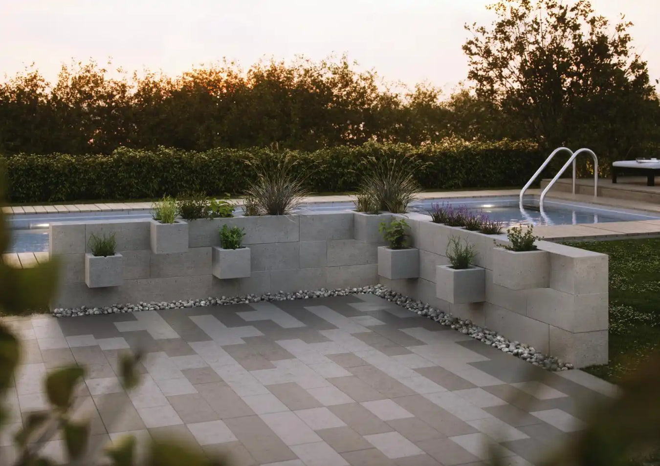 Utendørs terrasse med en støttemur og plantet grøntområde.